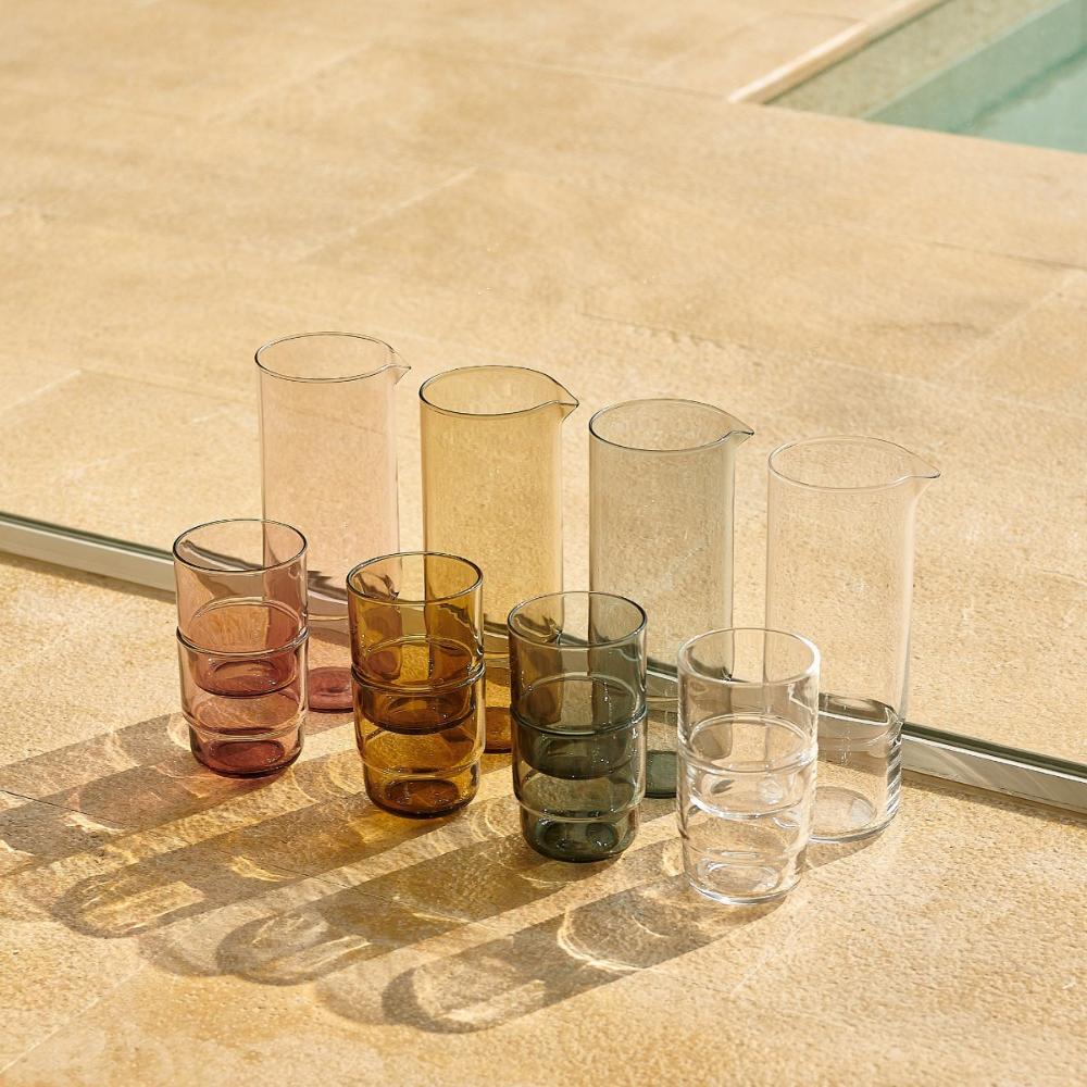 Colourful drinking glasses and coloured glass carafes