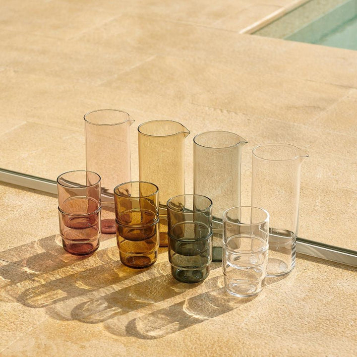 Colourful drinking glasses and coloured glass carafes